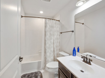 Bathroom featuring vanity, shower / tub combo, and tile patterned floors