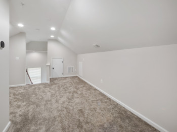 Bonus room featuring lofted ceiling and carpet flooring