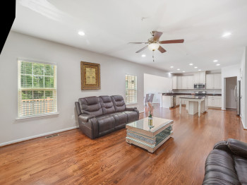 Living room with recessed lighting, light wood-type flooring, and a ceiling fan