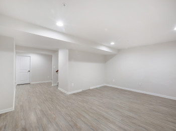 Finished below grade area with light wood finished floors and recessed lighting