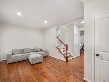 Living area with ornamental molding, wood finished floors, stairway, and recessed lighting