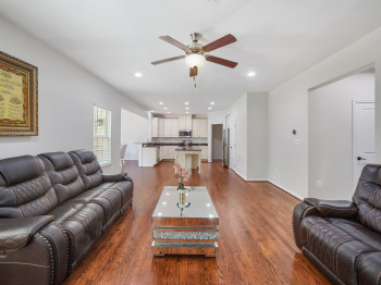 Living area with dark wood-type flooring, recessed lighting, and a ceiling fan