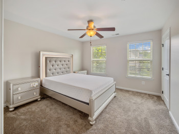 Carpeted bedroom featuring baseboards and a ceiling fan