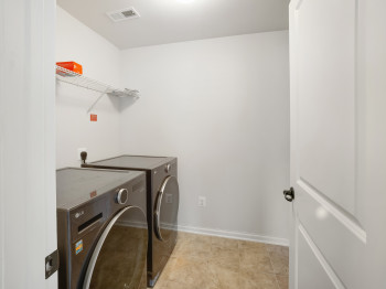 Washroom with separate washer and dryer and baseboards