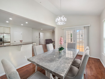 Dining area featuring dark wood-type flooring, lofted ceiling, a ceiling fan, a chandelier, and recessed lighting