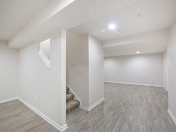 Finished basement featuring wood finished floors, stairway, and recessed lighting