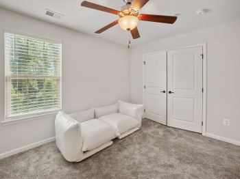 Living area featuring carpet flooring and a ceiling fan