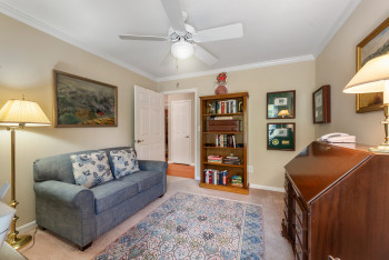 Sitting room with crown molding, light carpet, and a ceiling fan