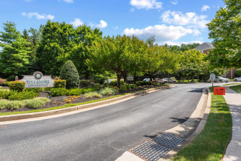 View of asphalt road featuring curbs, traffic signs, and sidewalks