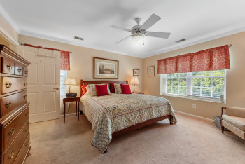 Bedroom featuring ornamental molding, light colored carpet, and ceiling fan
