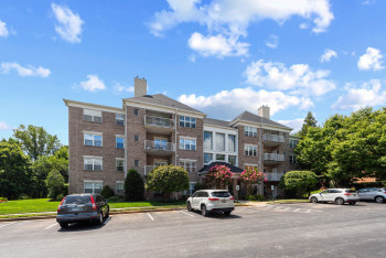 View of apartment building / complex with uncovered parking