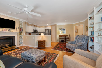 Living area with built in features, crown molding, light wood-style floors, recessed lighting, and a fireplace