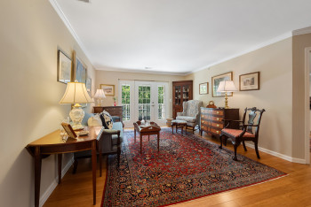 Living room featuring light wood-type flooring, ornamental molding, and french doors