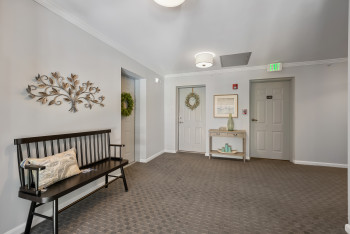 Entrance foyer with ornamental molding and dark carpet