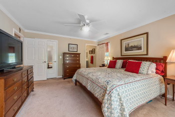Bedroom with crown molding, light colored carpet, and ceiling fan