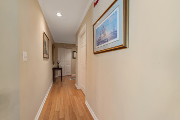 Hall with light wood-type flooring, ornamental molding, and recessed lighting