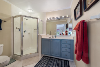 Full bath featuring light tile patterned floors, a shower stall, vanity, and crown molding