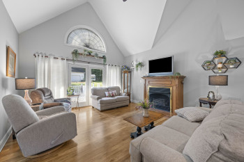 Bright living room with vaulted ceilings, leads out to new deck