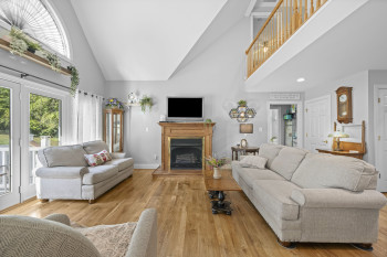 Bright living room with vaulted ceilings, leads out to new deck