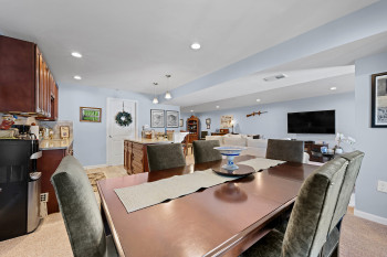 Dining space with light colored carpet and recessed lighting