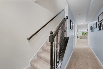 Stairs with carpet flooring and recessed lighting