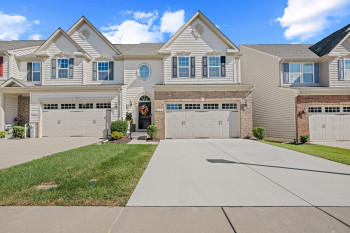 Main front of Villa home featuring 2 car driveway, brick siding, an attached 2 car garage.