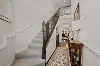 Stairway featuring a towering ceiling, carpeting and beautiful designer railing.