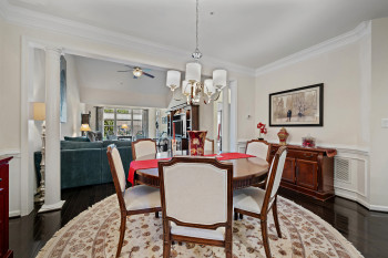 Dining area with ornamental molding, decorative columns, wainscoting and dark wood flooring,
