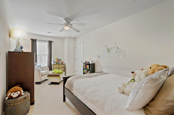 Upper level Bedroom 2 featuring light colored carpet and ceiling fan and still a generous size