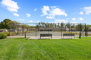 View of tennis court featuring a residential view and a gate