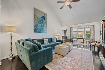 Large Living area with high vaulted ceiling, dark wood flooring,  ceiling fan and arched doorways