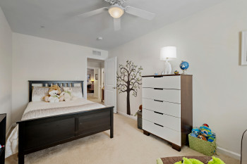 Upper level Bedroom 2 featuring light carpet and a ceiling fan