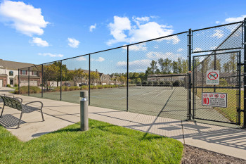 View of basketball court with a gate, a tennis court, and a residential view