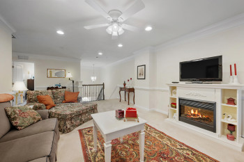 Living room with crown molding, recessed lighting, light carpet, a fireplace, and ceiling fan