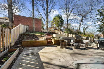 Lovely, large patio with brick retaining wall and path to garage