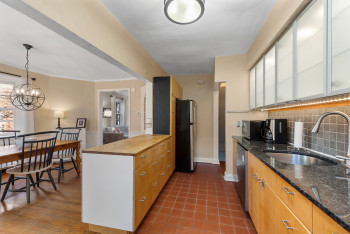 Granite countertops with butcher block top on pass-through peninsula
