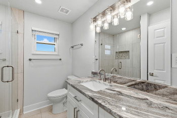 Primary Bathroom featuring vanity, a shower stall, light tile patterned floors, and recessed lighting