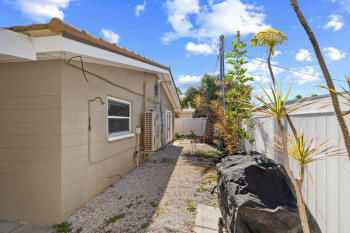 View of side of home with a fenced backyard and stucco siding