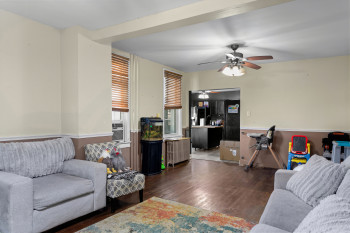 Living area featuring radiator, dark wood-style floors, and ceiling fan