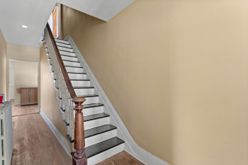 Stairs featuring wood finished floors and recessed lighting