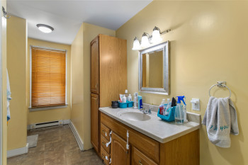 Bathroom with vanity, a baseboard radiator, and stone finish flooring