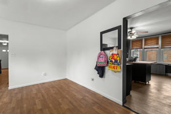 Spare room featuring dark wood finished floors, radiator heating unit, and a ceiling fan