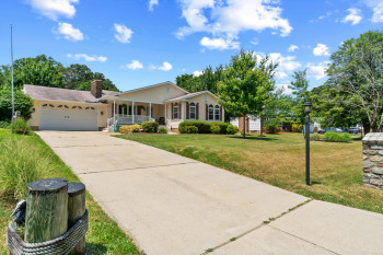 Ranch-style residence featuring a prominent front porch, attached one-car garage, and a concrete driveway
