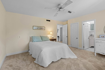 Carpeted room with a ceiling fan, light-toned walls, and white trim