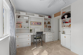 Built-in desk and shelving unit featuring a central workstation, integrated drawers, and open shelving