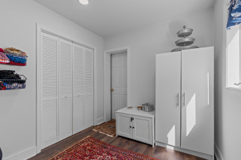White louvered bifold closet doors with dark wood-finish flooring