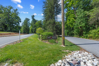 Roadside signage with a wooden fence and natural rock landscaping