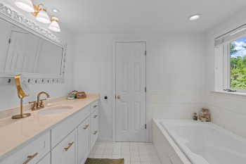 Bathroom featuring a built-in soaking tub and a window