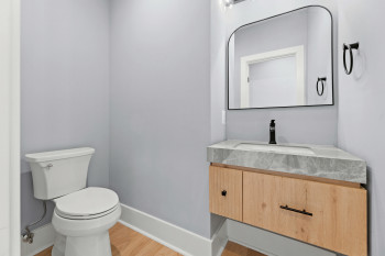 Floating vanity with a built-in sink, stone countertop, and wood-finish cabinetry