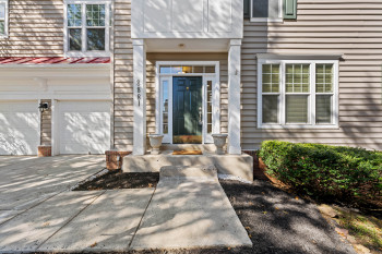 Horizontal siding exterior with a prominent front entry, two-car garage, and established landscaping